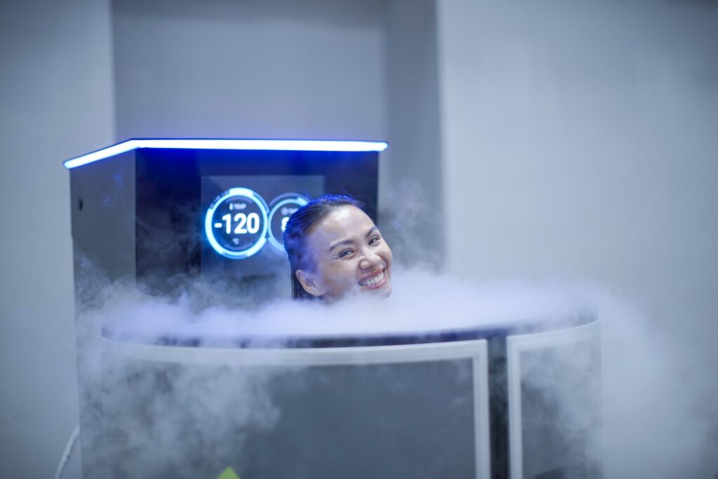 Người phụ nữ mỉm cười khi trải nghiệm liệu pháp cryotherapy ở nhiệt độ -120°C để trị liệu cơn đau